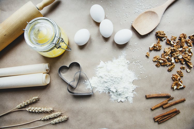 Baking ingredients and tools including eggs, flour, cinnamon, cookie cutters, and a rolling pin