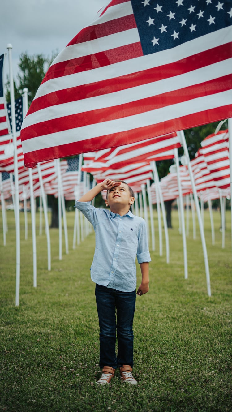 Boy saluting a row of American flags