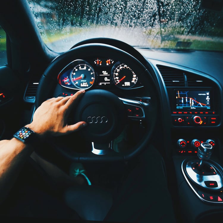 A car's cockpit while driving in the rain.