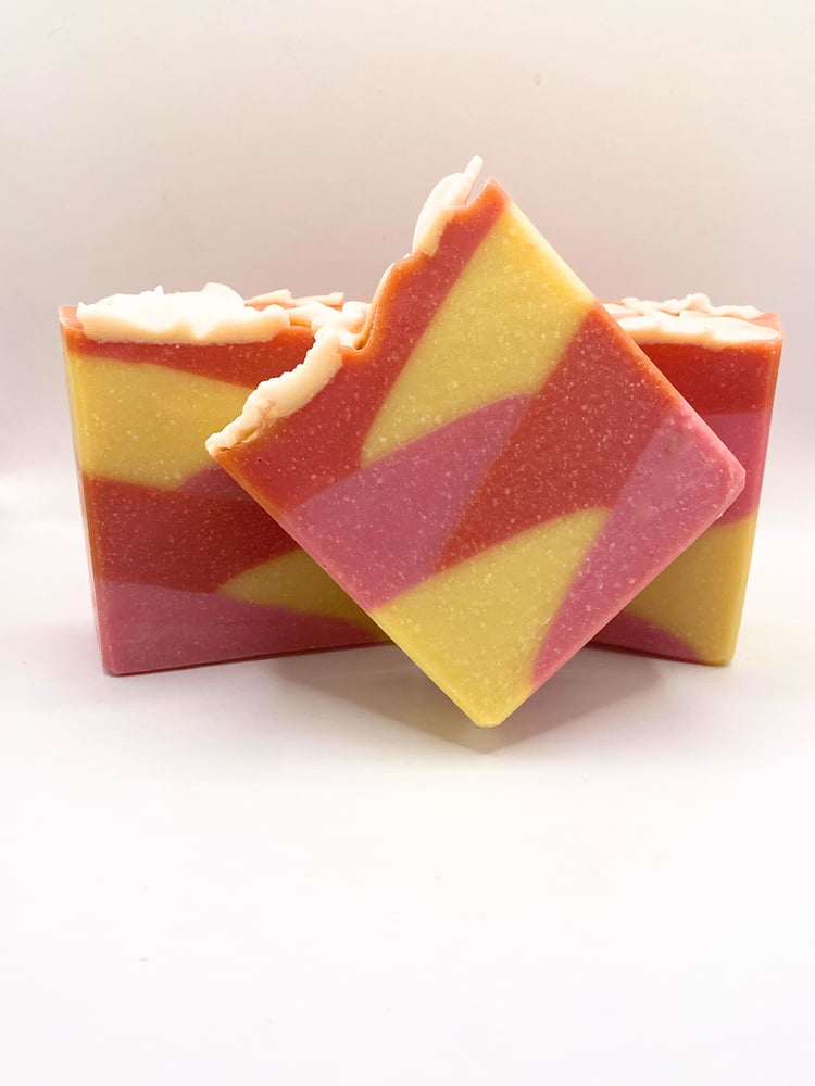 Stack of Handmade tropical blossom soaps Layered with the colors of tropical blooms and topped with soap flowers