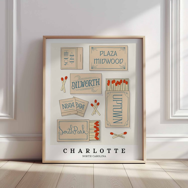 A framed picture of Charlotte, North Carolina neighborhoods drawn in various lettering styles on matchboxes. Artwork has a beige and blue color scheme