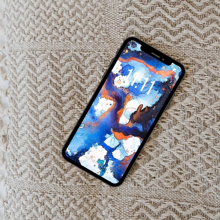 Abstract phone wallpaper featuring deep cobalt, blue, and bronze hues with a cosmic-inspired design and shimmering metallic accents.