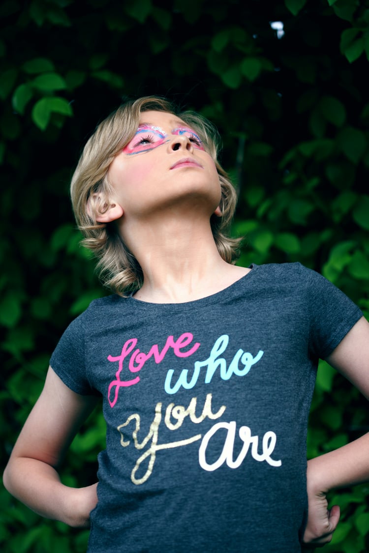 YOung person, standing proudly. Wearing a shirt that reads - Love who you are