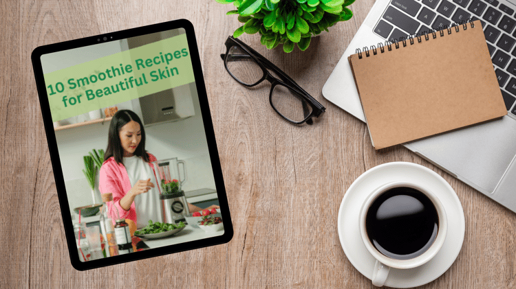 A woman in a pink shirt prepares a green smoothie in a modern kitchen, adding fresh spinach to a blender. The text "10 Smoothie Recipes for Beautiful Skin" is displayed in green at the top of the image. Fresh ingredients like berries, greens, and suppleme