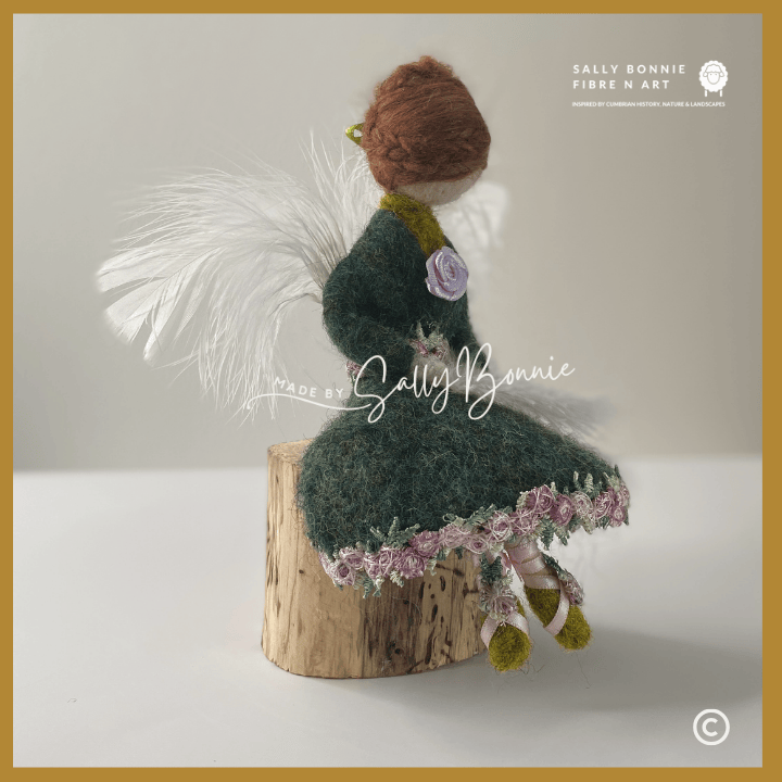 needle felted angel sitting on a wooden block