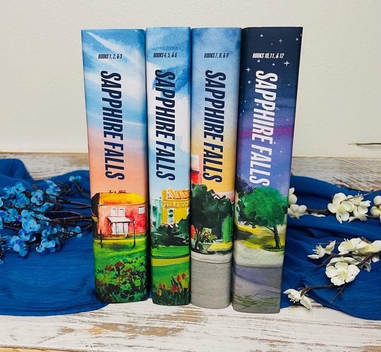 Spines of hardback Sapphire Falls special edition books 1-12, split into 4 volumes
