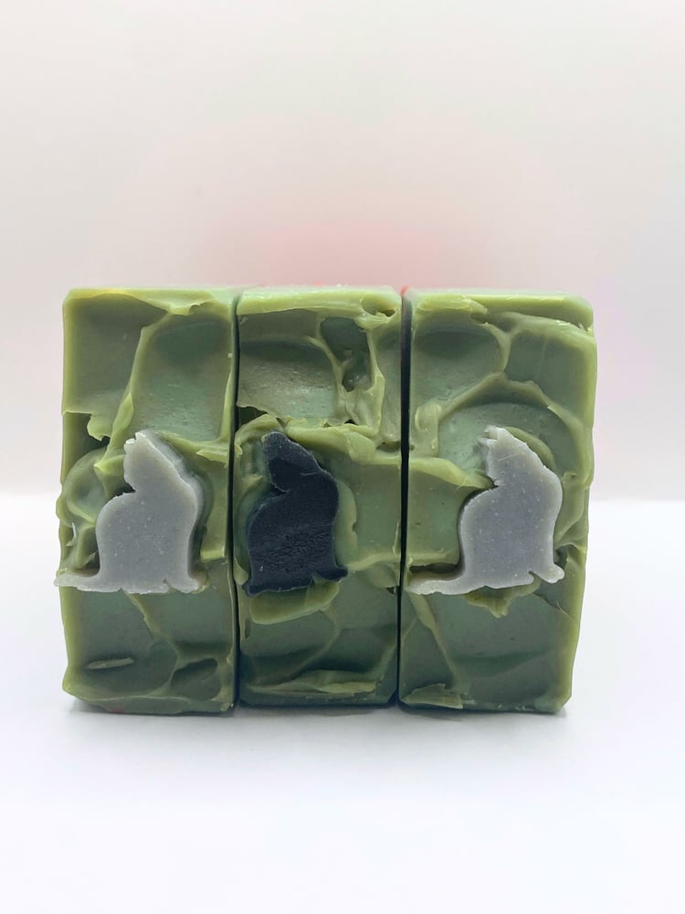 Hemingway's Cats handmade soap shows a black cat and a gray cat sitting on a brick wall in the author's Key West home