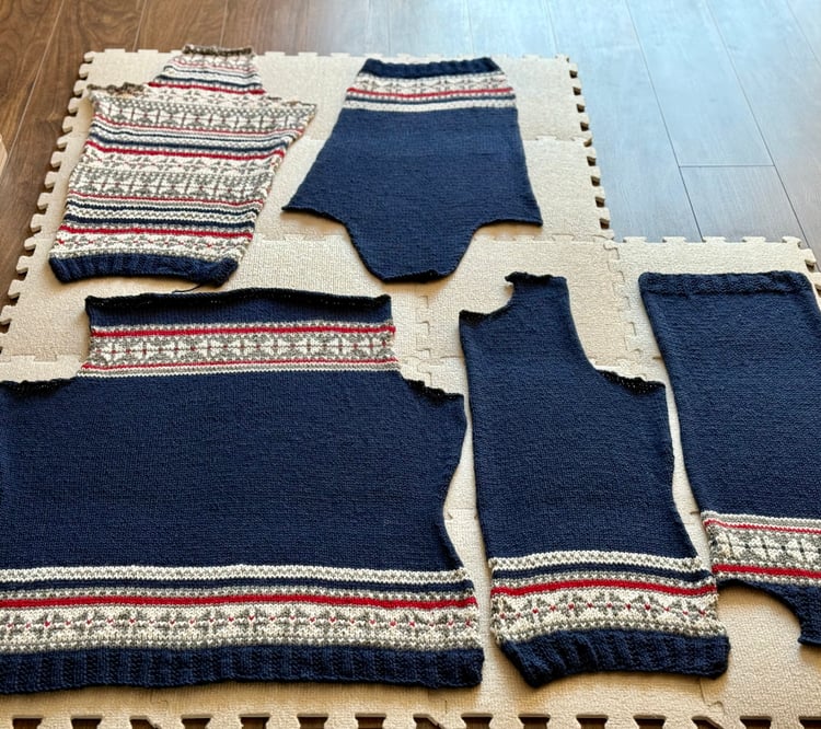 A sweater in pieces blocking on mats