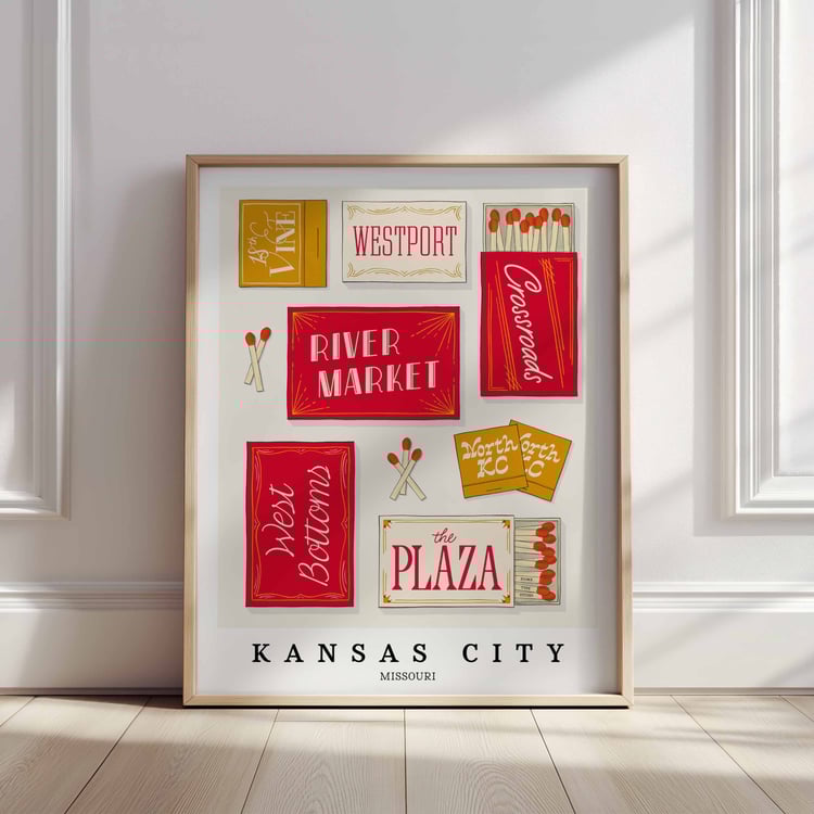 A framed picture of Kansas City, Missouri neighborhoods drawn in various lettering styles on matchboxes. Artwork has a red and gold color scheme