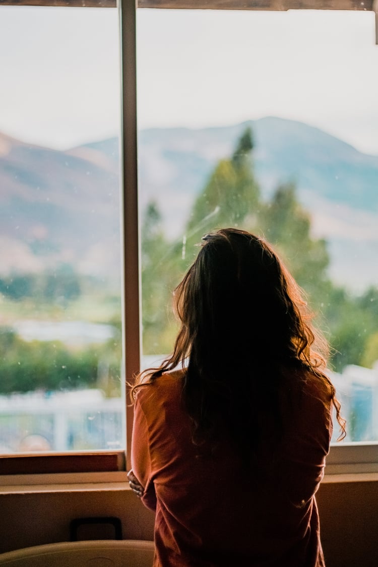 Woman stands at window