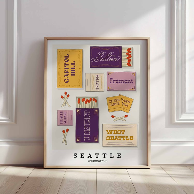 A framed picture of Seattle, Washington neighborhoods drawn in various lettering styles on matchboxes. Artwork has a purple and yellow color scheme