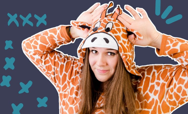 An image of a woman in a giraffe onesie, with her hands placed around her head held up like they are ears