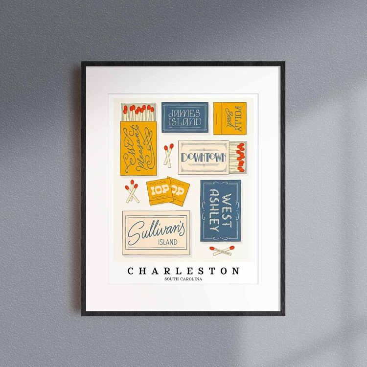 A framed picture of Charleston, South Carolina neighborhoods drawn in various lettering styles on matchboxes. Artwork has a blue, yellow and beige color scheme.