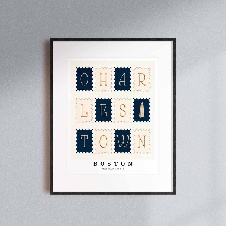 A framed picture of postage stamps featuring the Charlestown neighborhood in Boston, Massachusetts drawn in a unique lettering style. Artwork has a nautical color scheme of navy blue and beige