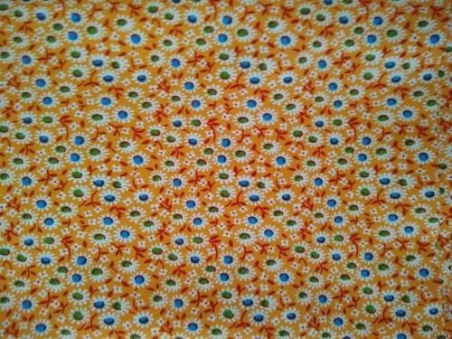 MDG 100% cotton fabric featuring teal blue flower centers with white petals and stems on a medium and dark orange background, unwashed and folded in a 3-yard cut