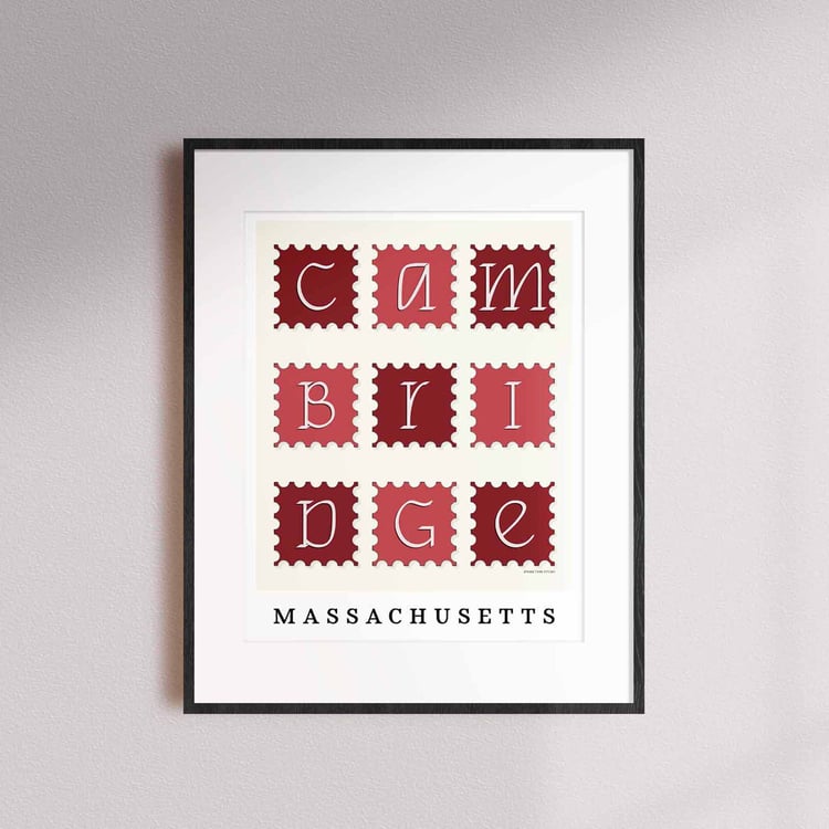 A framed picture of postage stamps featuring Cambridge, Massachusetts drawn in a unique lettering style. Artwork has a red and white color scheme