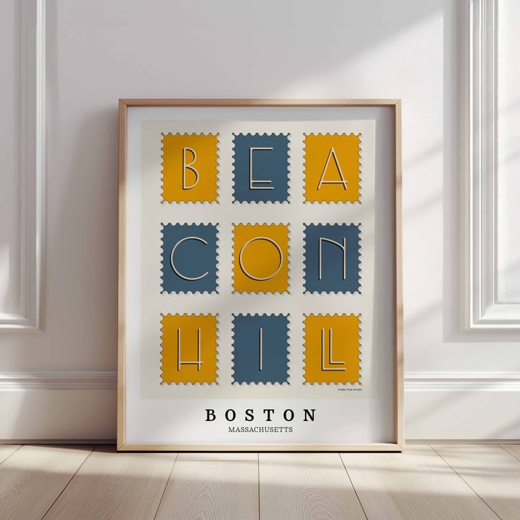 A framed picture of postage stamps featuring the Beacon Hill neighborhood in Boston, Massachusetts drawn in a unique lettering style. Artwork has a blue and yellow color scheme