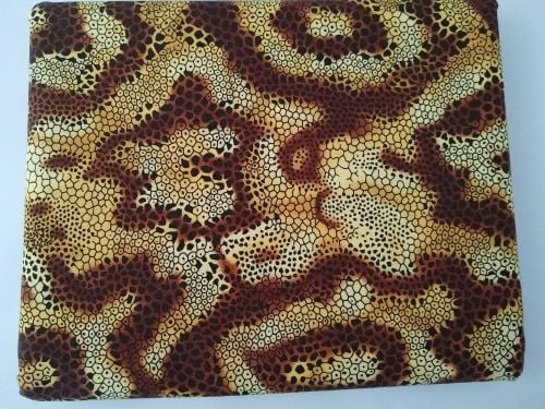 A 3-yard cut of medium-weight cotton fabric with a brown snakeskin print on a beige background, neatly rolled and displayed, perfect for garments and crafts.