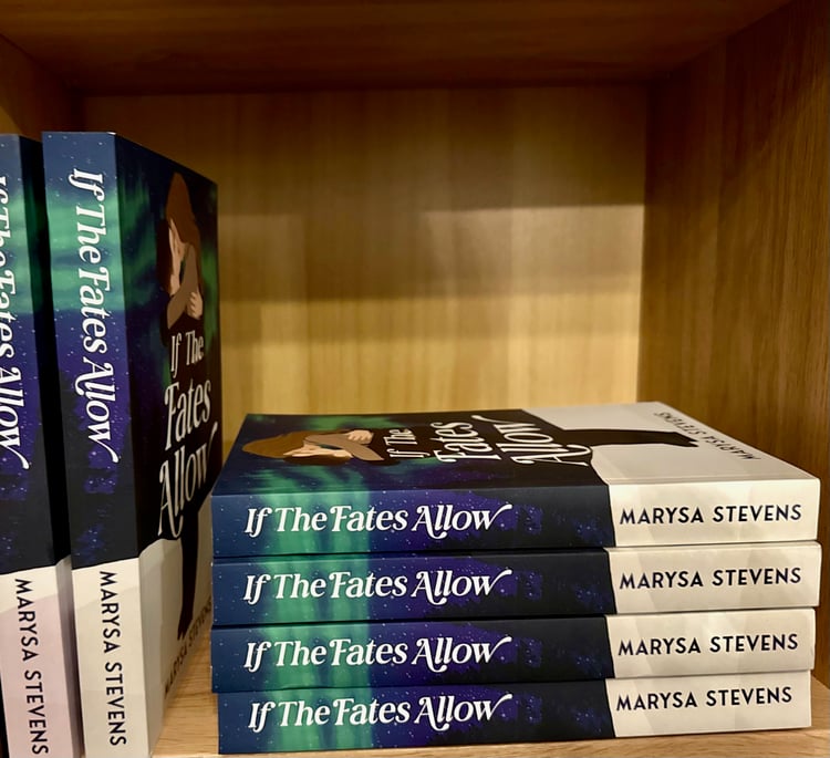 paperback cover with couple in a romantic embrace in front of the northern lights of green, blue and deep purple