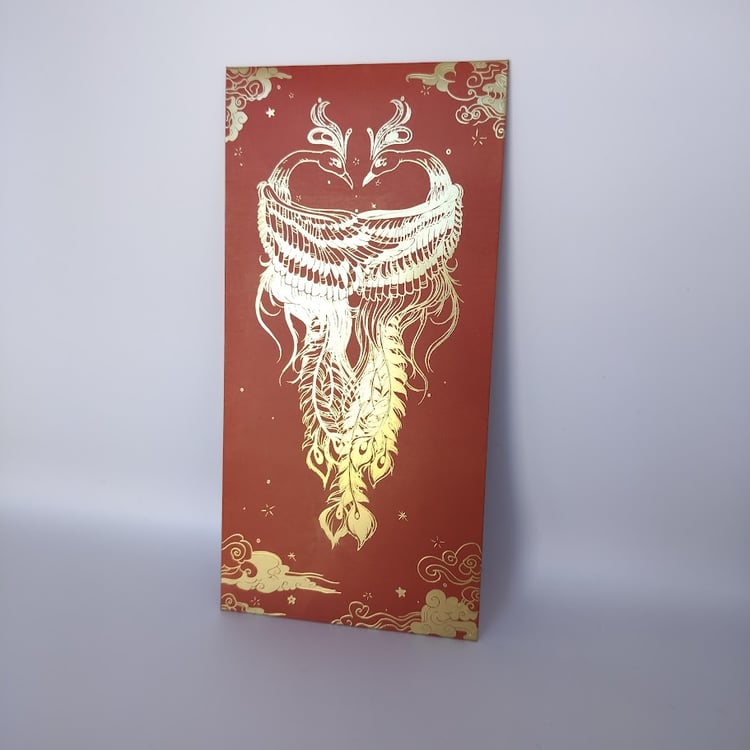 Red money envelope with elaborate gold foil design featuring two phoenixes with detailed feathers, decorative clouds, and ornamental border elements.