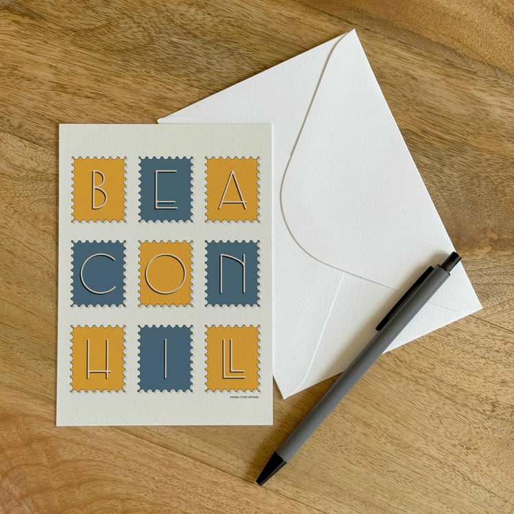 A colorful notecard sitting on a table with a white envelope and pen.