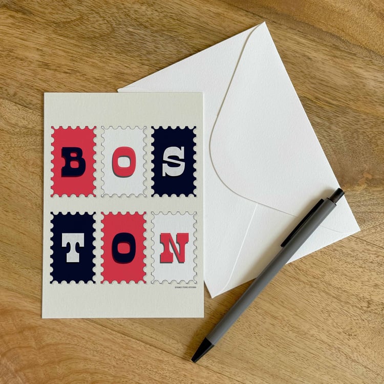 A colorful notecard sitting on a table with a white envelope and pen.