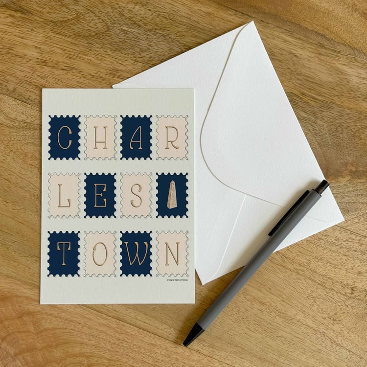 A colorful notecard sitting on a table with a white envelope and pen.
