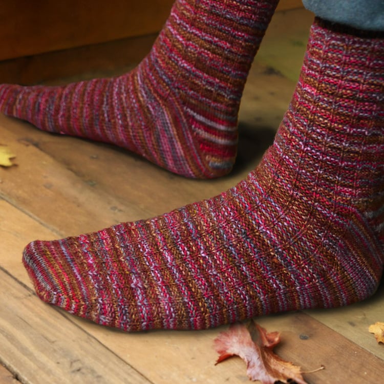 Closeup of top and side of the waffle weave unisex Adventure Socks knitting pattern, showing the raglan toe shaping, waffle weave texture, and short-row gusset heel.