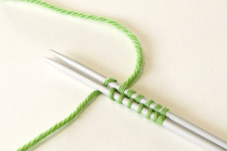 Two parallel needles with cast on stitches on both.