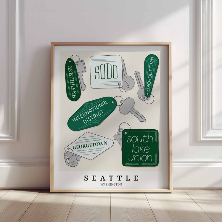 A framed picture of Seattle neighborhoods drawn in various lettering styles on key fobs. Artwork has a green and white color scheme