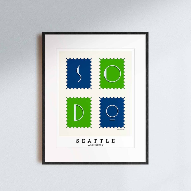 A framed picture of postage stamps featuring the SoDo neighborhood in Seattle, Washington drawn in a unique lettering style. Artwork has a bright blue and green color scheme