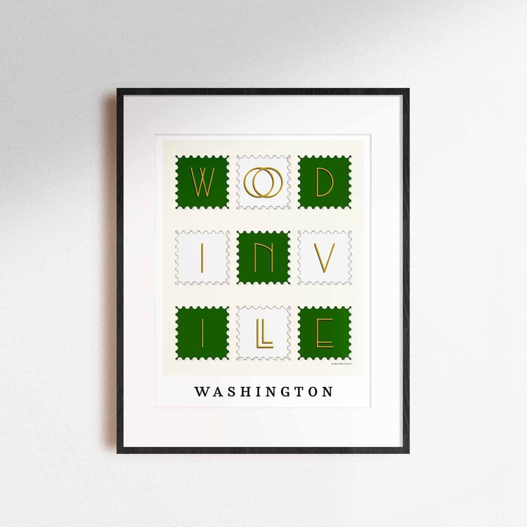 A framed picture of postage stamps featuring Woodinville, Washington drawn in a unique lettering style. Artwork has a green, white and yellow color scheme