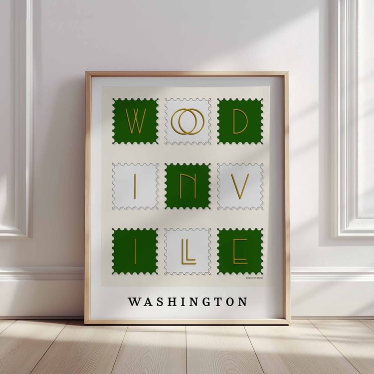 A framed picture of postage stamps featuring Woodinville, Washington drawn in a unique lettering style. Artwork has a green, white and yellow color scheme
