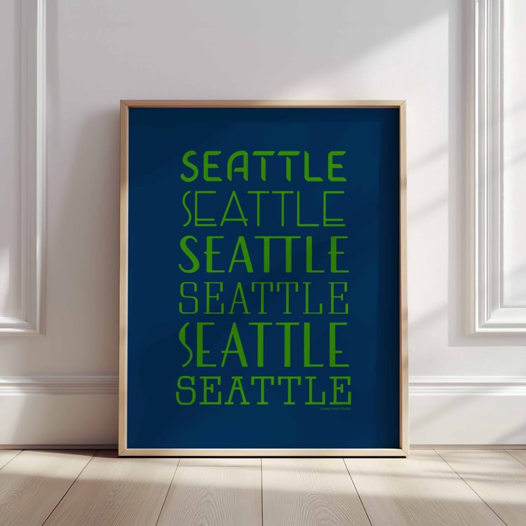 A framed picture of the word "Seattle" drawn in various lettering styles. Artwork has a bright blue and green color scheme