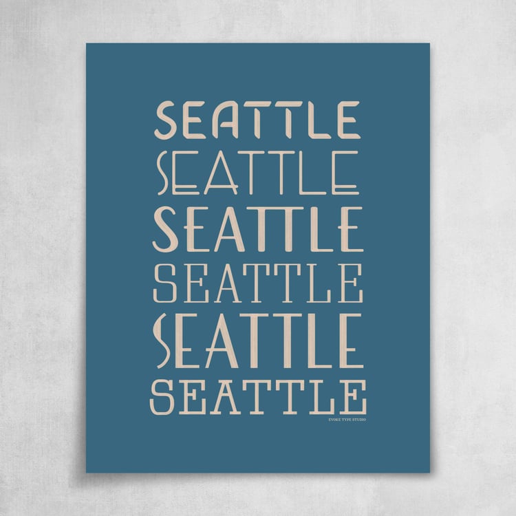 A collection of the word "Seattle" drawn in various lettering styles. Artwork has a blue and beige color scheme.