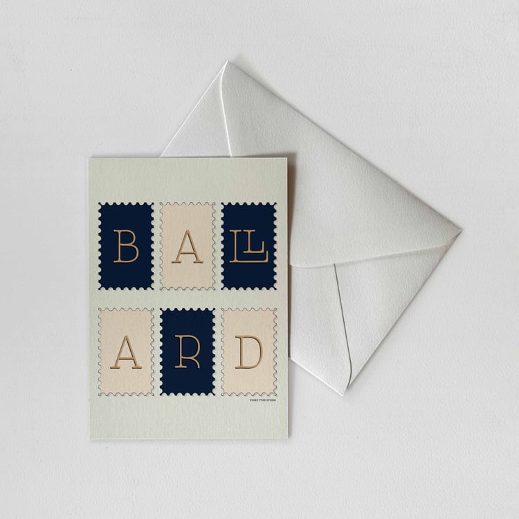 A notecard of postage stamps featuring the Ballard neighborhood in Seattle, Washington drawn in a unique lettering style with a white envelope. Artwork has a navy blue, beige and tan color scheme