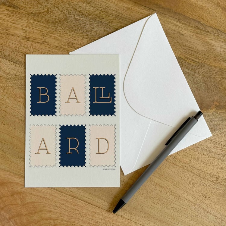 A colorful notecard sitting on a table with a white envelope and pen.