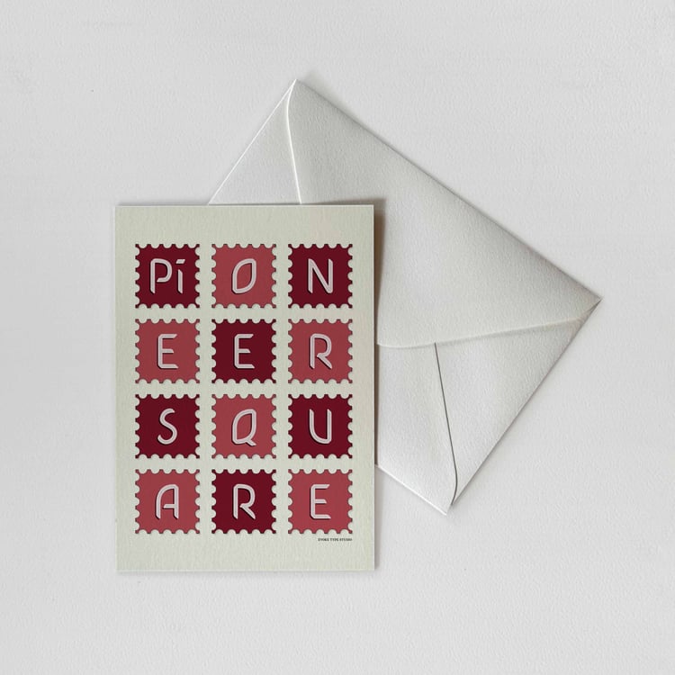 A notecard of postage stamps featuring the Pioneer Square neighborhood in Seattle, Washington drawn in a unique lettering style with a white envelope. Artwork has a red and white color scheme