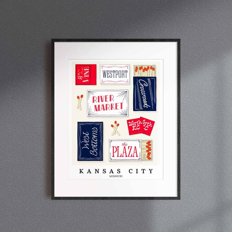 A framed picture of Kansas City, Missouri neighborhoods drawn in various lettering styles on matchboxes. Artwork has a red, white and blue color scheme
