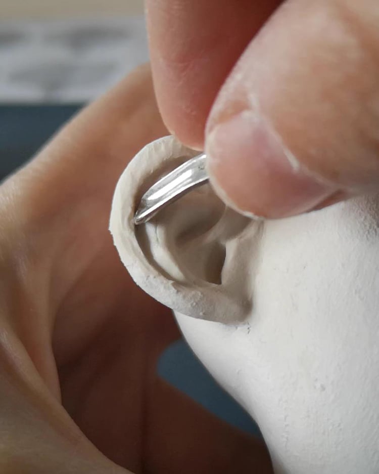 Close-up of puppet head sculpting – shaping ear details using air-dry clay.