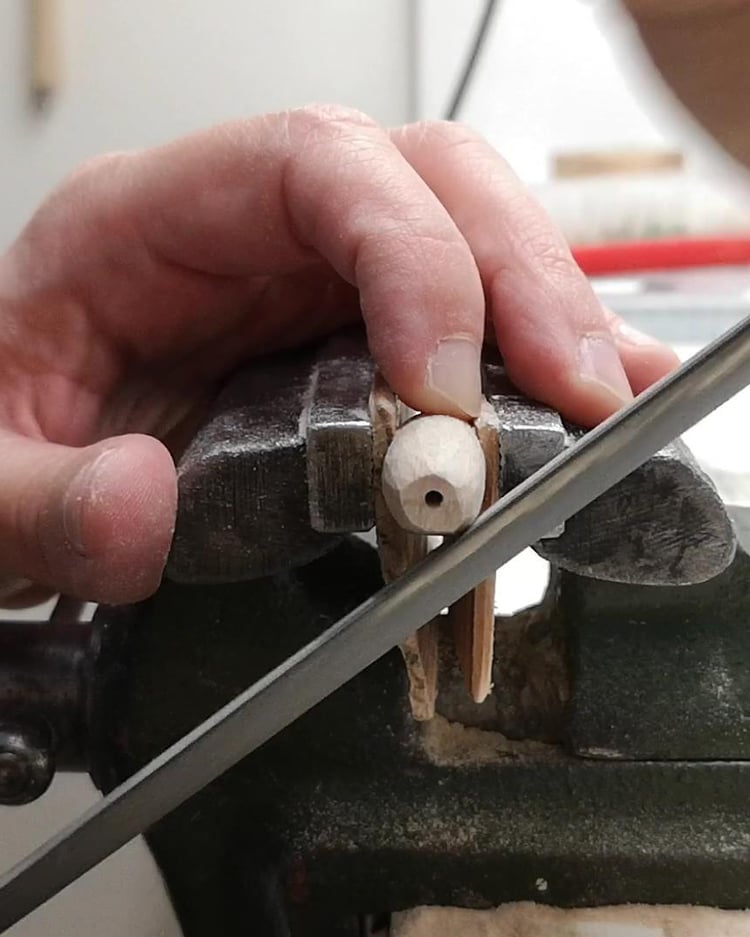 DIY puppet-making – refining marionette arm details using a file and vise.