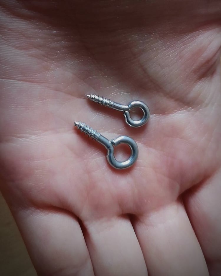 Close-up of eye screws for DIY marionette making – puppet joint hardware.