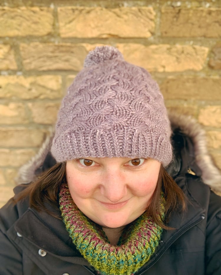 Hand knit hat with pom pom. Sample knit and designed by Su Sayer