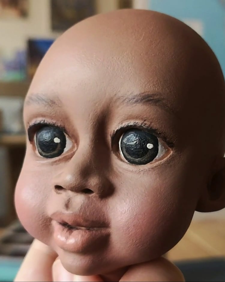 Hand-painted marionette head without hair – puppet face of a young girl with a beautiful dark skin tone.