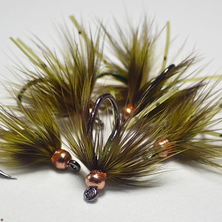 Small pile of Olive Lil Dynamite wet flies, designed by Matt Campbell for trout, panfish, and carp.