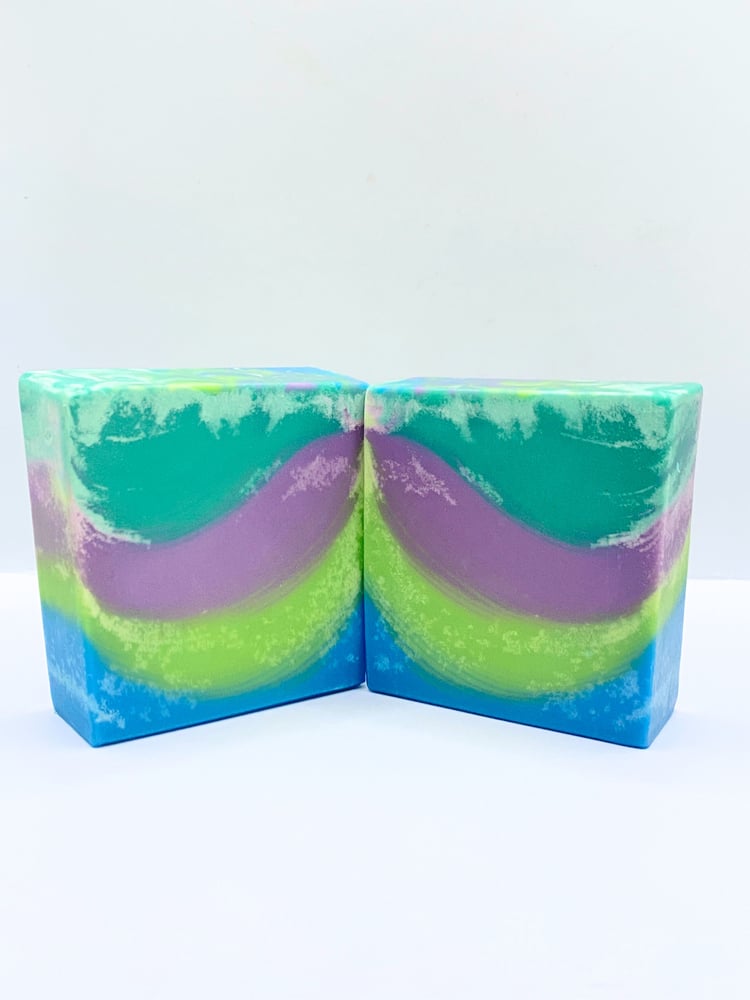 Handmade soap scented with rosemary essential oil and swirled with green, purple, teal, and blue