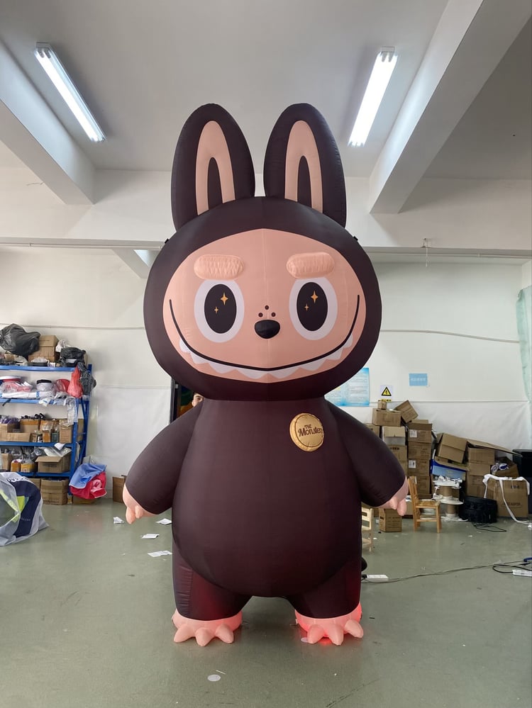 Giant Labubu style inflatable character with big eyes and LED lights at a party