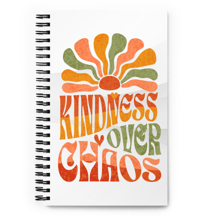 Spiral notebook with soft-touch cover featuring the phrase “Kindness Over Chaos” in retro typography.