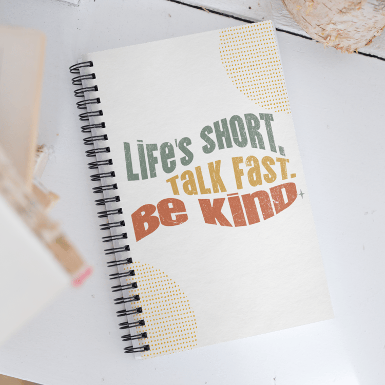 Spiral notebook with retro lettering that reads “Life’s Short. Talk Fast. Be Kind.”