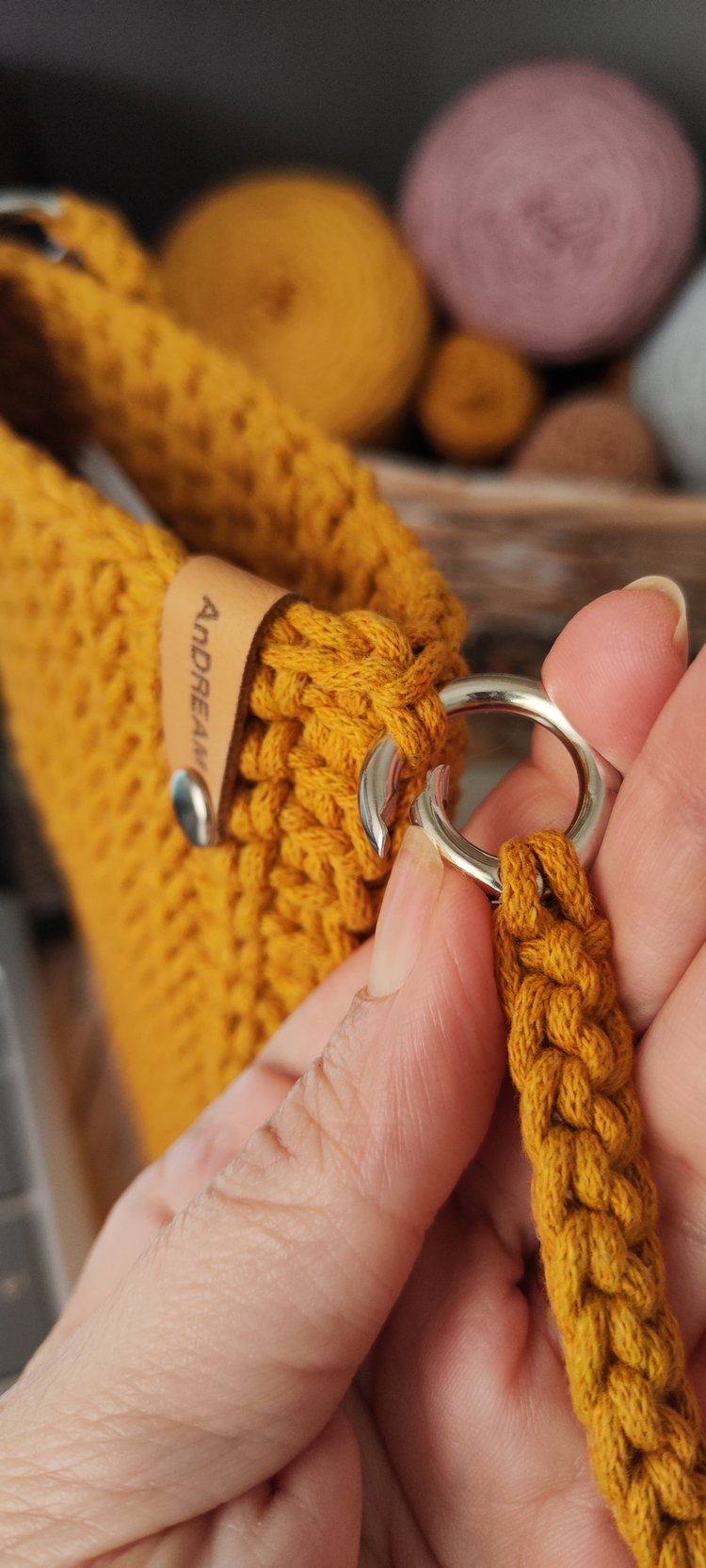 Mustard colour rope-yarn minimalist handbag with knit-purl texture, styled on wooden surface for crochet pattern inspiration